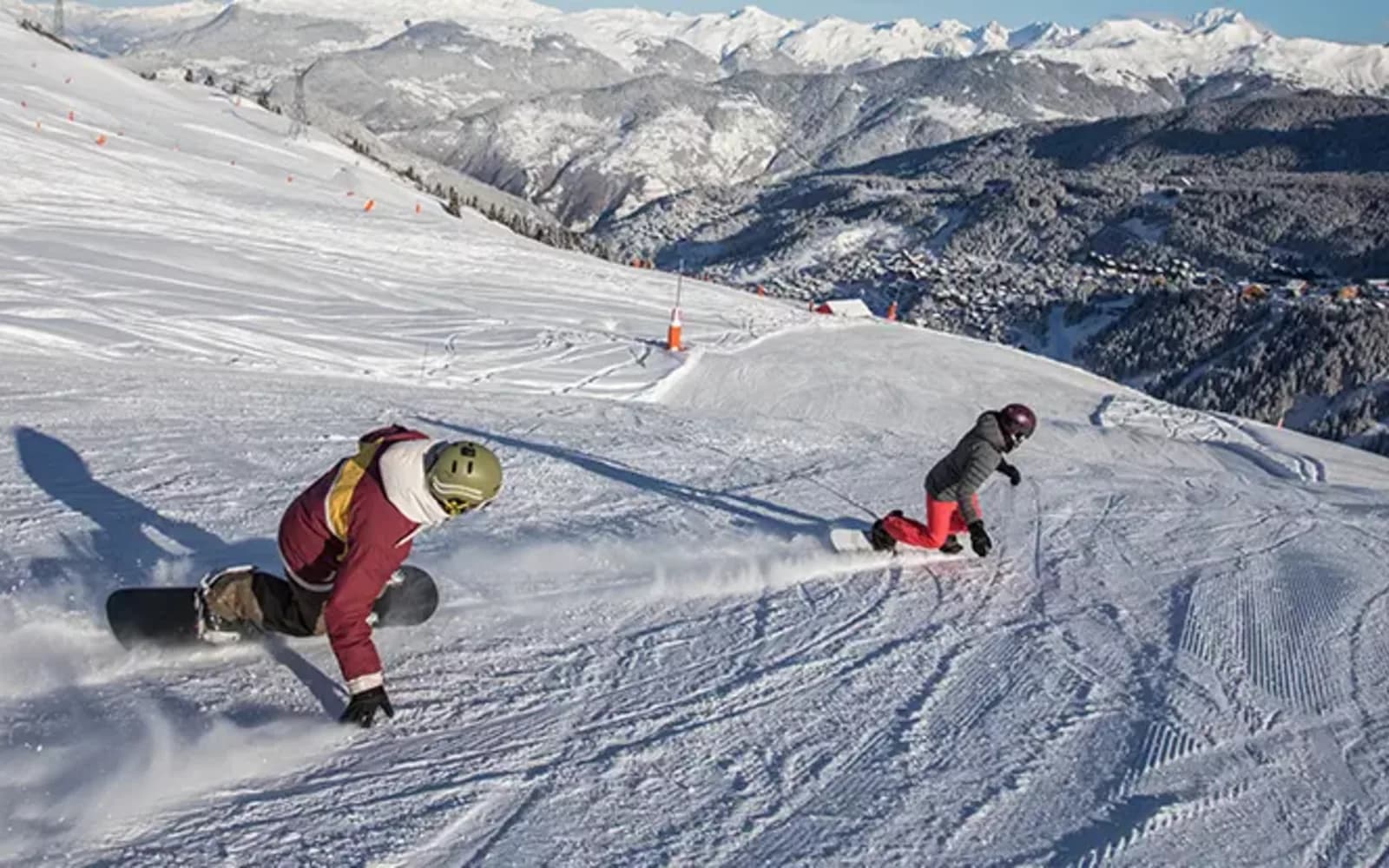 Snowboardeur en action dans le snowpark de Méribel-Mottaret avec le Mont Vallon en arrière-plan