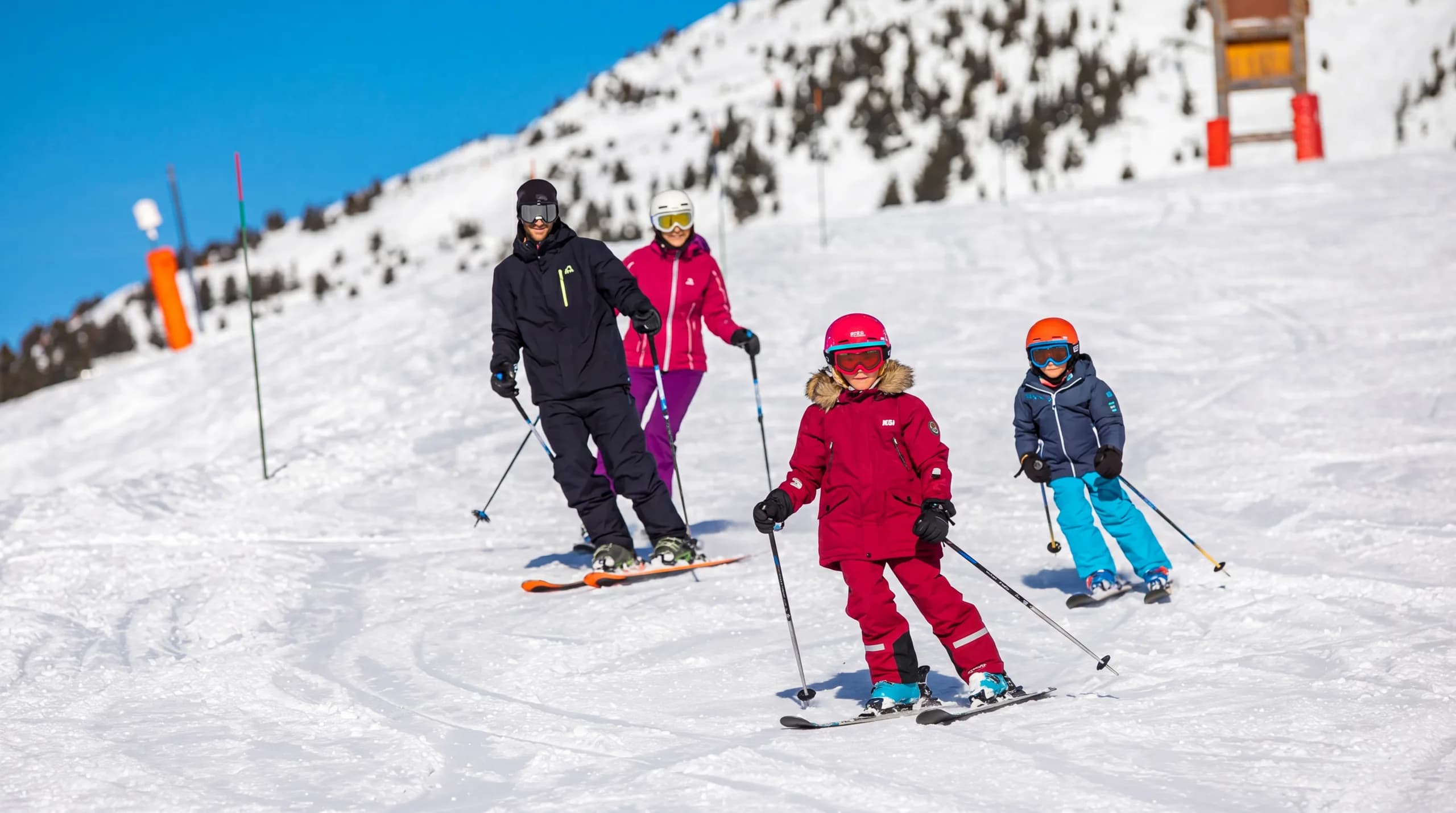 Groupe de débutants en cours de ski sur une piste verte de Méribel, encadrés par un moniteur