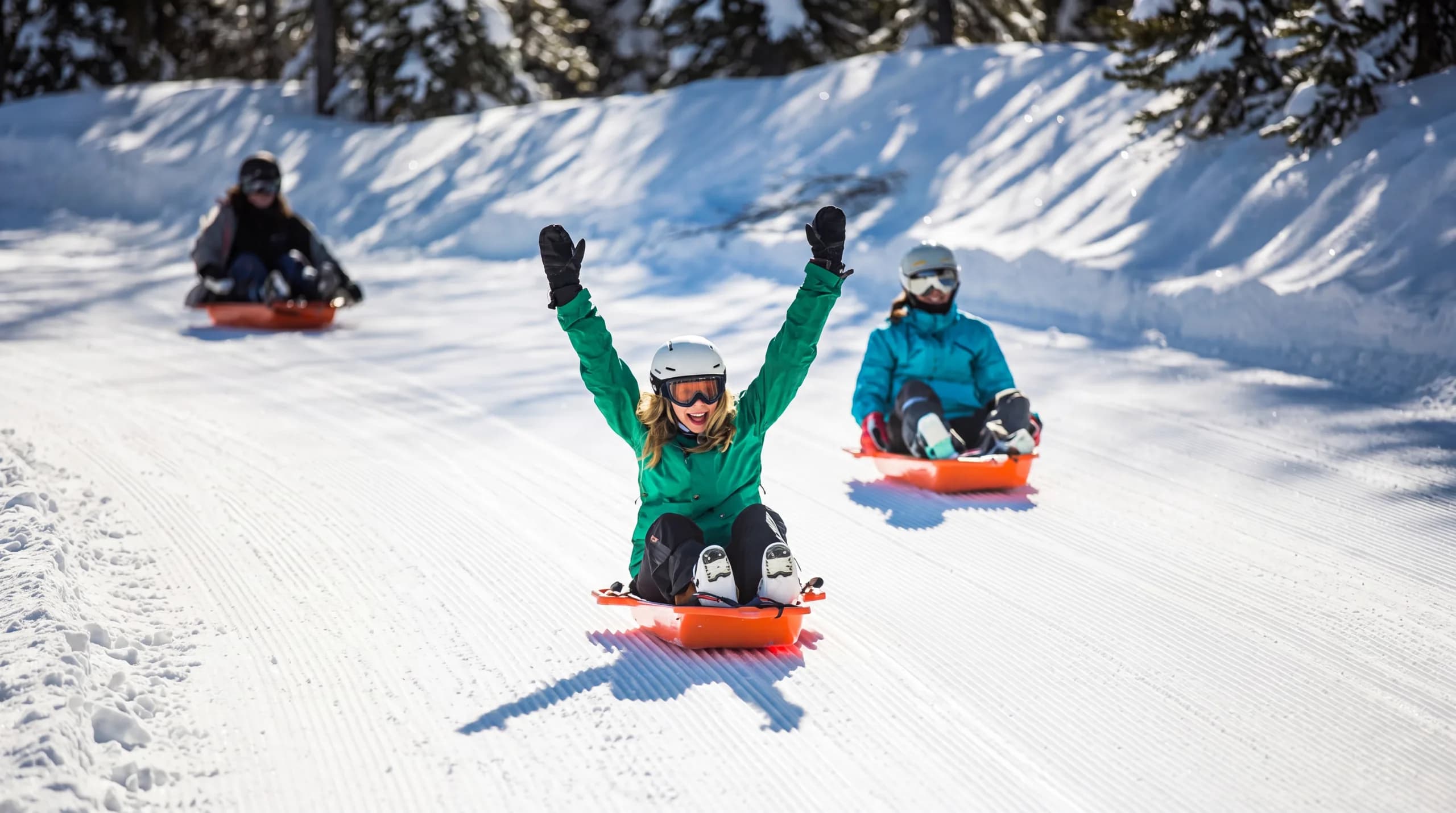 Enfants en luge sur la piste Mission Black Forest dans la forêt enneigée de Méribel-Mottaret