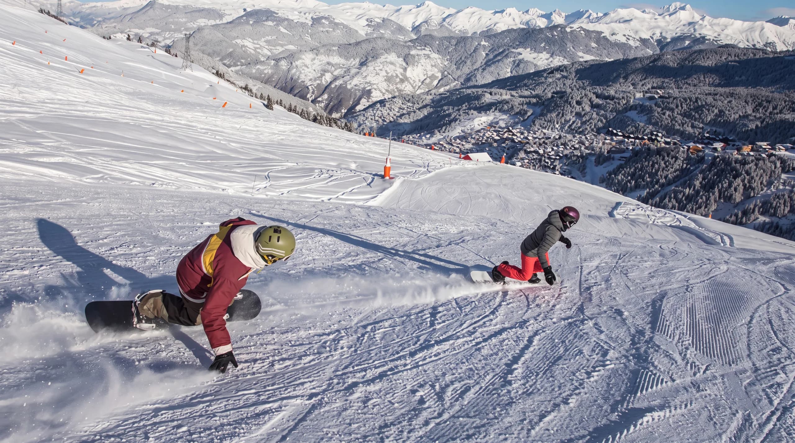 Snowboardeur en action dans le snowpark de Méribel-Mottaret avec le Mont Vallon en arrière-plan