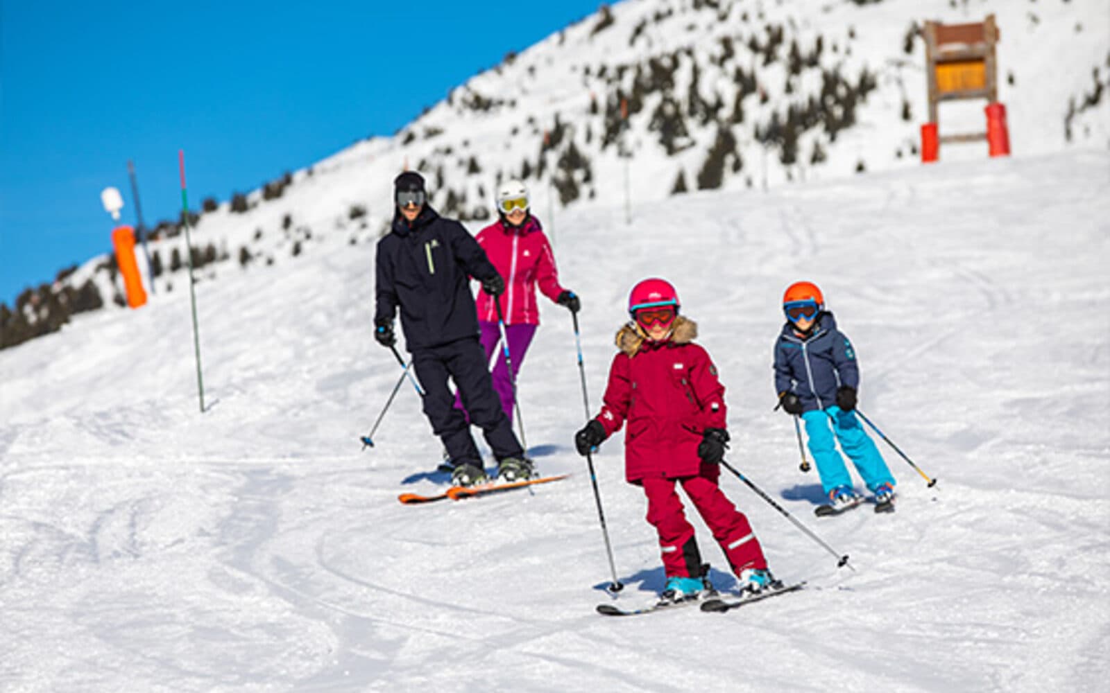 Groupe de débutants en cours de ski sur une piste verte de Méribel, encadrés par un moniteur