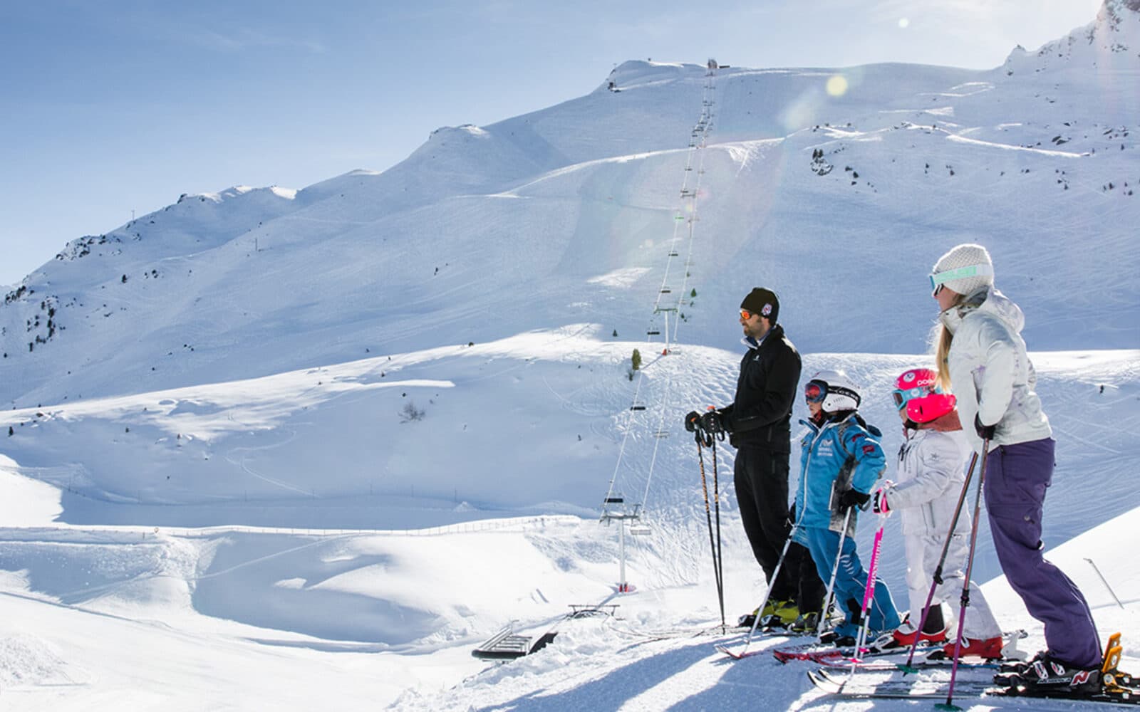 Famille skiant ensemble sur les pistes enneigées du domaine familial de Méribel