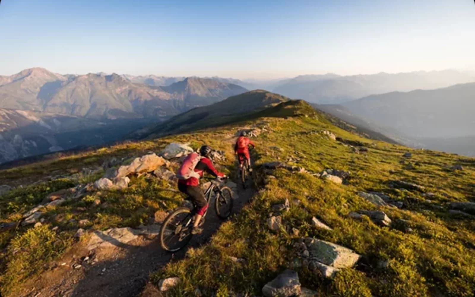 VTT descendant une piste du bike park de Méribel entre les mélèzes en automne