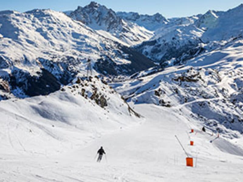 Skieurs sur la piste du Roc de Fer à Méribel avec vue sur les 3 Vallées